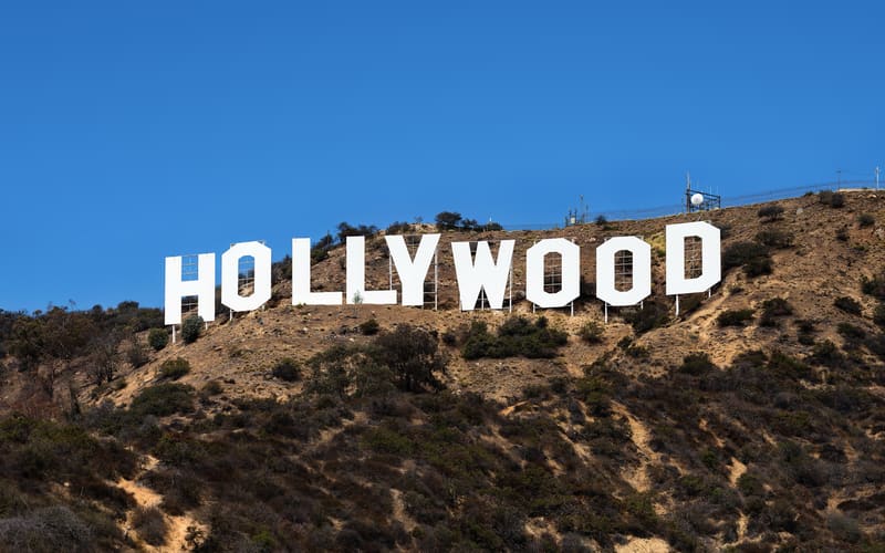 The white Hollywood sign on a dry hillside above Los Angeles under a blue sky