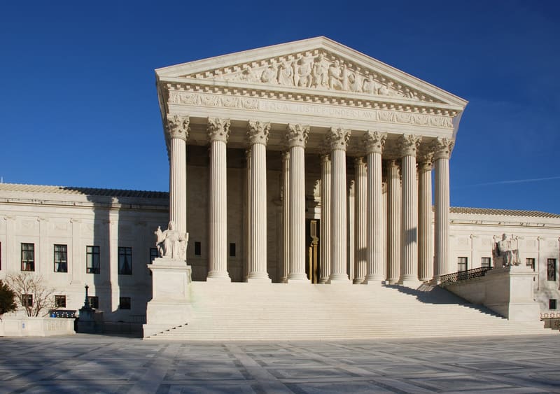 White marble facade of the US Supreme Court with tall columns and wide steps