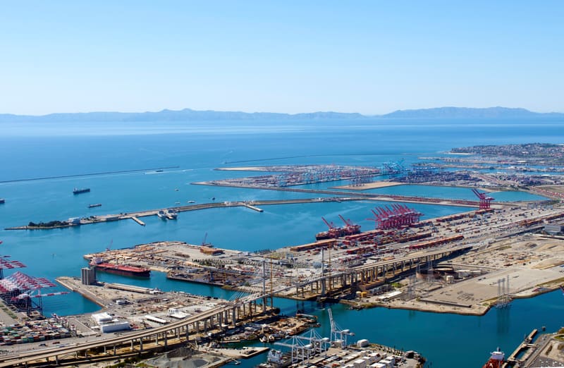 Stacks of shipping containers and large cranes along the docks at the Port of Los Angeles and Long Beach
