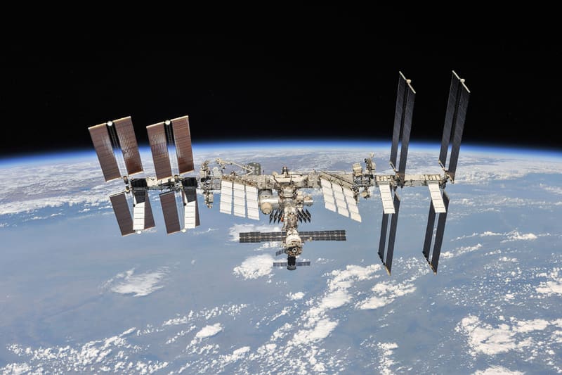 The International Space Station with its large solar panels, seen against the Earth