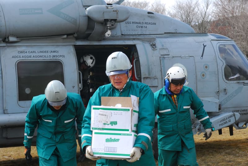 US military personnel unloading boxes of humanitarian relief supplies